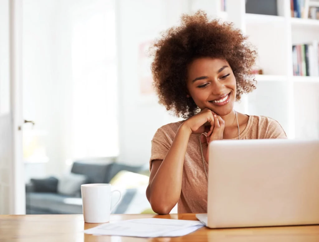 Happy woman looking at laptop